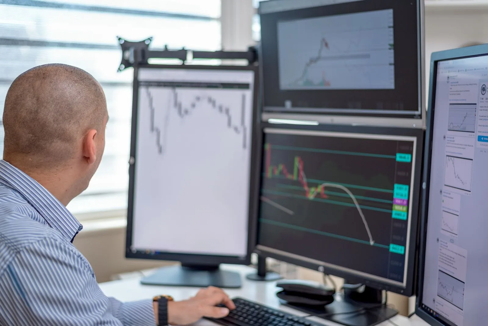 Focused young trader looking at a computer screen in a dark office