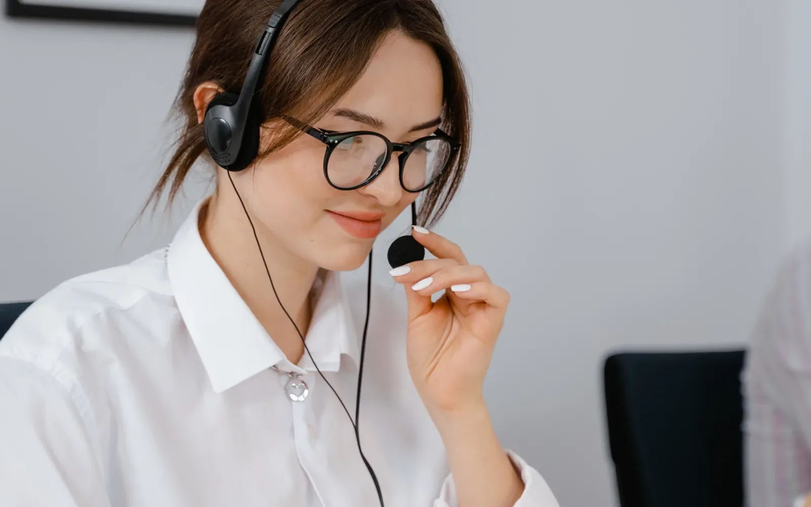 Customer support representative with headset smiling in an office