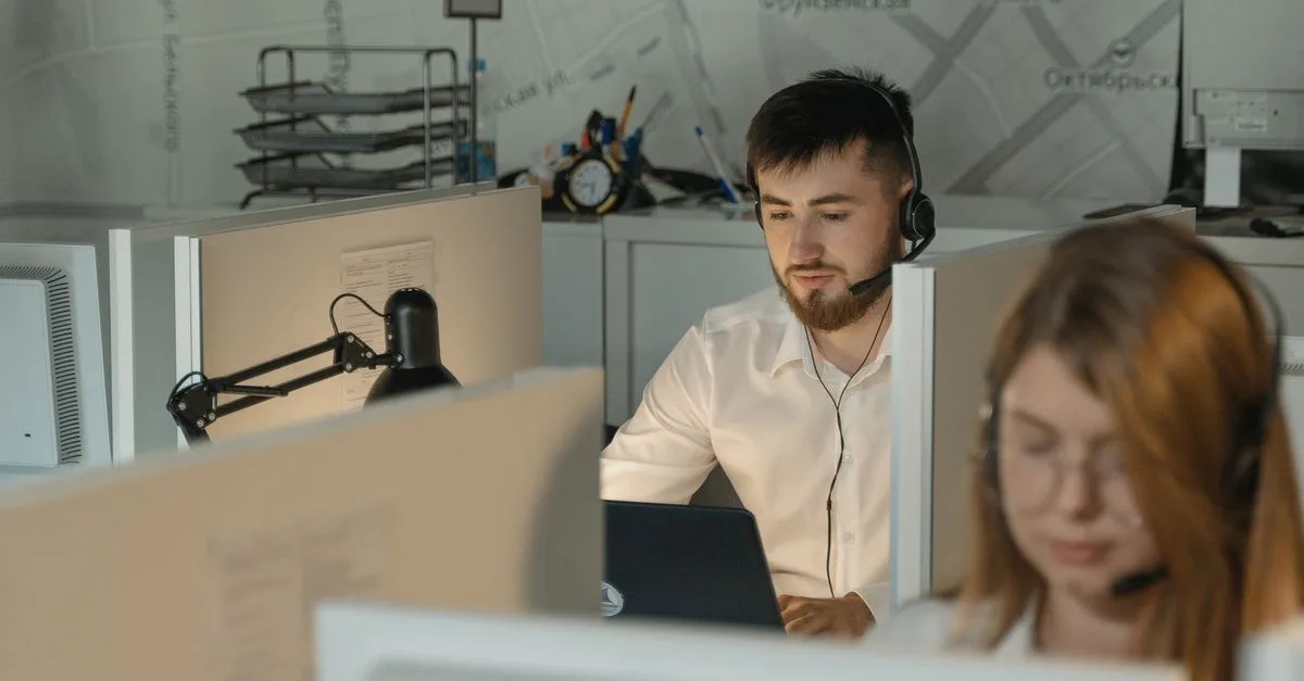IT support technician helping a colleague at a desk